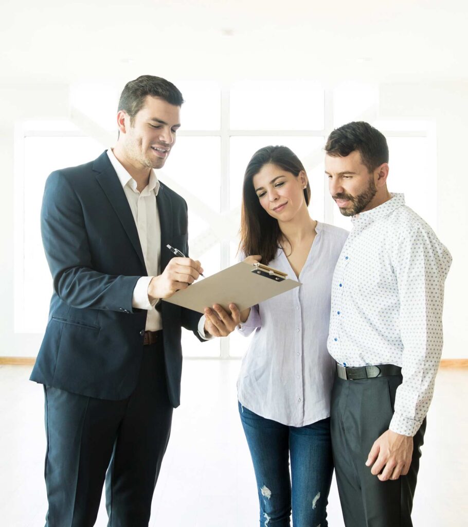 Three individuals stand in an empty room, one holding a clipboard, discussing plans or notes. image | Featured image for the TL property lawyers Brisbane page
